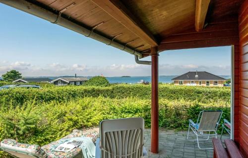a screened porch with chairs and a view of the ocean at 2 Bedroom Lovely Home In Faaborg in Faaborg