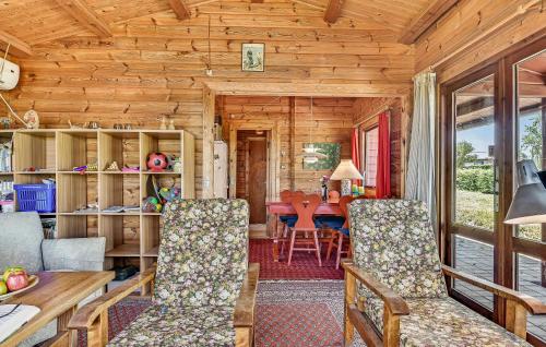 a dining room and living room of a log cabin at 2 Bedroom Lovely Home In Faaborg in Faaborg