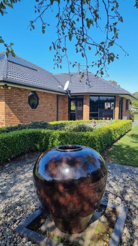 a large vase sitting in front of a house at Rosandra Retreat 2 in New Plymouth