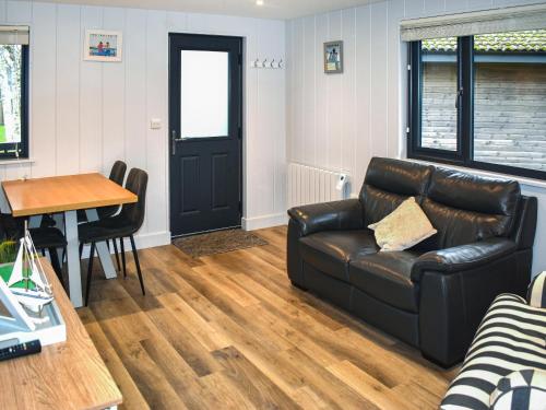 a living room with a leather couch and a table at Lodge 6- Uk51084 in Lyme Regis