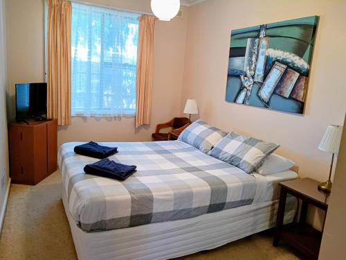 a bedroom with a bed with two towels on it at Lakes Entrance Holiday Units in Lakes Entrance