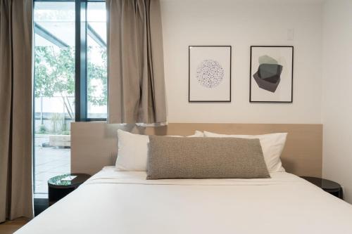 a bedroom with a white bed and a window at Smithe House in Vancouver