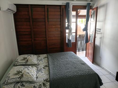 a bedroom with a bed in a room with a door at TRANSIT AFFAIRES - LOISIRS in Pointe-à-Pitre