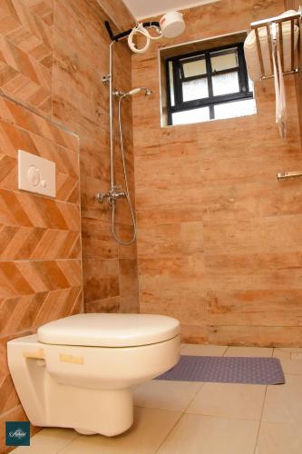 a bathroom with a toilet and a shower at Fahari Cedar House in Kericho