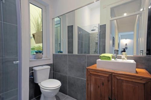 La salle de bains est pourvue de toilettes, d'un lavabo et d'un miroir. dans l'établissement HOME4U, à Lisbonne