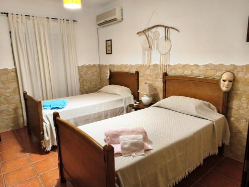 a bedroom with two beds and a skull on the wall at Casa D Dinis by NaturAlegre in Alegrete