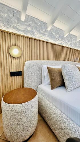 ein Zimmer mit einem Bett, einer Couch und einem Hocker in der Unterkunft Tramonto Maisonettes & Suites in Parga