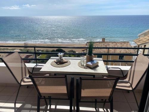 a table and chairs on a balcony with the ocean at Glyfada Seaview Home 126 by New Era in Glyfada