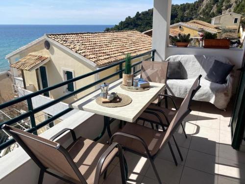 a balcony with a table and chairs and the ocean at Glyfada Seaview Home 126 by New Era in Glyfada