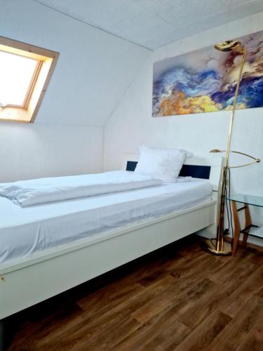 a bed in a room with a painting on the wall at Apartments by Pension Pale Bach in Bad Hersfeld