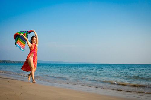 a woman running on the beach with a kite at Makathanee Resort in Ko Mak
