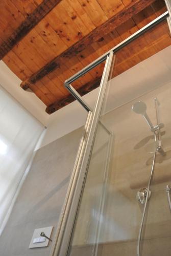 a shower in a bathroom with a wooden ceiling at Althamer Palace Apartments in Arco