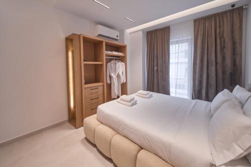 a bedroom with a large white bed and a window at SOLUNA Hideaway Athens - Luxury Jacuzzi Suite in Athens