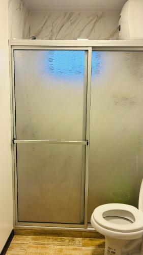 a shower stall with a toilet in a bathroom at Las andinas in Carmelo