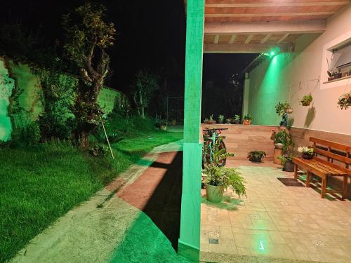 two photos of a patio at night with a bench at Solar das Oliveiras in Ibertioga