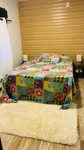 a bed with a colorful quilt in a bedroom at Las andinas in Carmelo