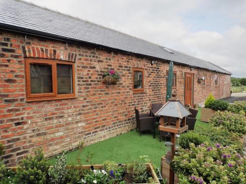 a brick house with a yard with green grass at The Byre in Great Ayton