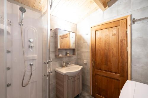 a bathroom with a sink and a wooden door at Golden Sun Bungalows in Palaiokatoúna