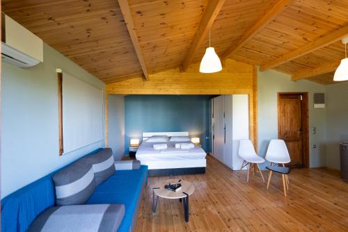 a bedroom with a bed and a couch and a table at Golden Sun Bungalows in Palaiokatoúna