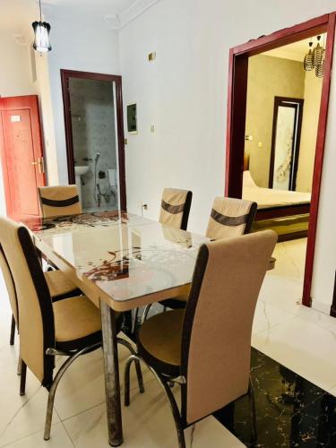 una sala da pranzo con tavolo, sedie e uno specchio di Résidence le Baron a Niaga