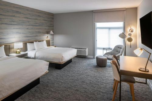 a hotel room with two beds and a desk at TownePlace Suites by Marriott Canfield in Canfield