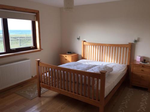 1 dormitorio con cama de madera y ventana en Holiday Home Croft46 en Clachan