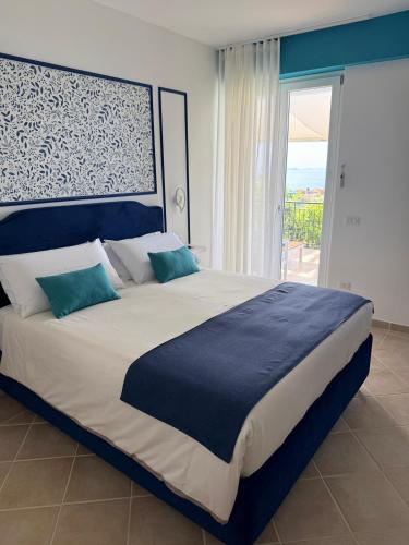 a bedroom with a large bed with a large window at Blu Vesuvius Sorrento in Sorrento