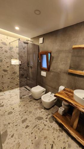 un bagno con WC, lavandino e doccia di Villas Jezerca a Valbona