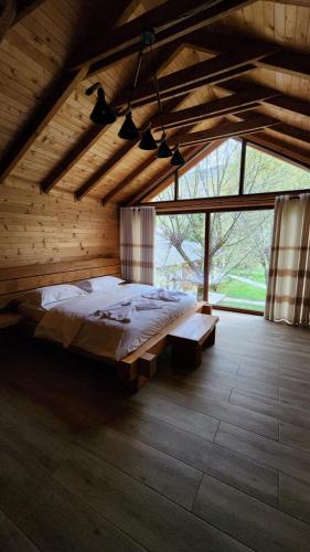 una camera da letto con un letto grande e una grande finestra di Villas Jezerca a Valbona