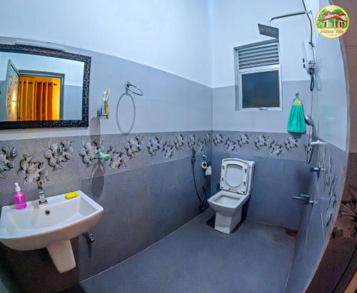 a bathroom with a sink and a toilet and a mirror at natura villa in Dickwella