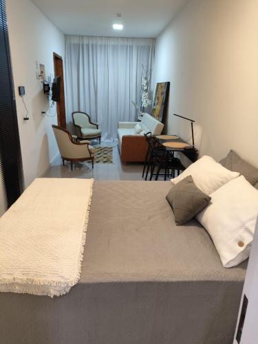 a bedroom with a bed and a living room at Loft 101 in Rio de Janeiro