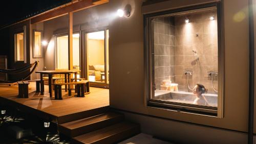a woman in a bath tub in a room at SAKURA YAKUSHIMA in Yakushima
