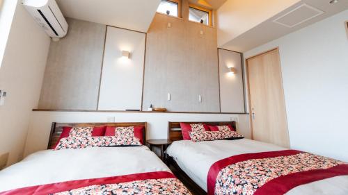 two beds sitting next to each other in a room at SAKURA YAKUSHIMA in Yakushima