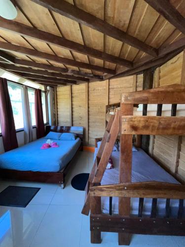 two bunk beds in a room with a wooden ceiling at Aire Agua y Naturaleza in Guácimo
