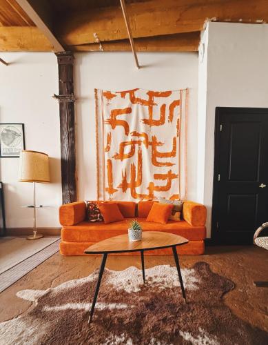 a living room with an orange couch and a table at 420 Friendly BOHO Loft Downtown KING suite FREE parking in Detroit