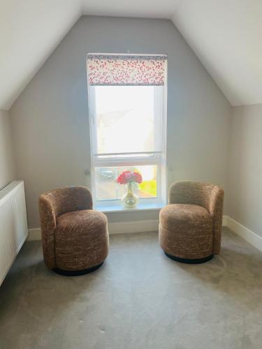 a room with two chairs and a window with an umbrella at Cozy Private Room & Breakfast Dublin 15 in Tyrrelstown