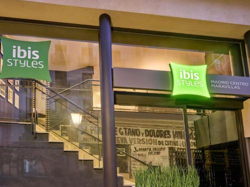 a store front with signs in the window of a store at Ibis Styles Madrid Centro Maravillas in Madrid