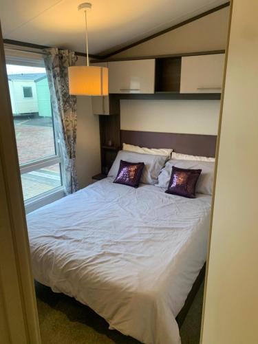 a bedroom with a large bed with two pillows at Lily's caravan in Meliden