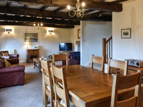 a dining room with a wooden table and chairs at Barn End in Watermillock