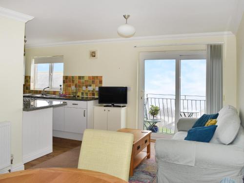 a kitchen and living room with a couch and a table at Dicks View in Ventnor