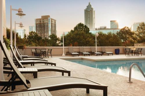 a group of lounge chairs and a pool on a building at Embassy Suites by Hilton Atlanta at Centennial Olympic Park in Atlanta