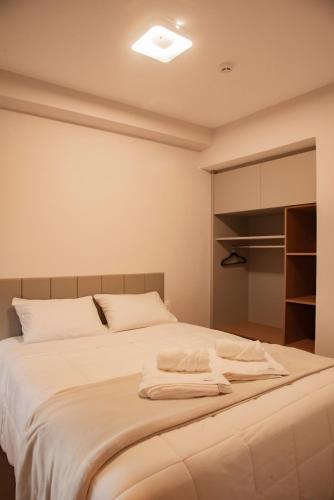 a bedroom with a large bed with white sheets at Essential 2U in São Paulo