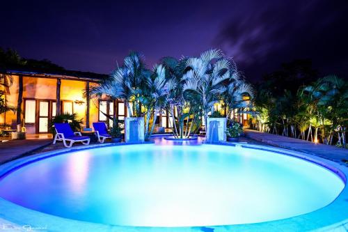 a large swimming pool in a backyard at night at Casa Lajagua in Pedasí Town