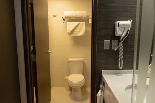 a bathroom with a toilet and a phone at Hotel Mirra San Luis in San Luis Río Colorado