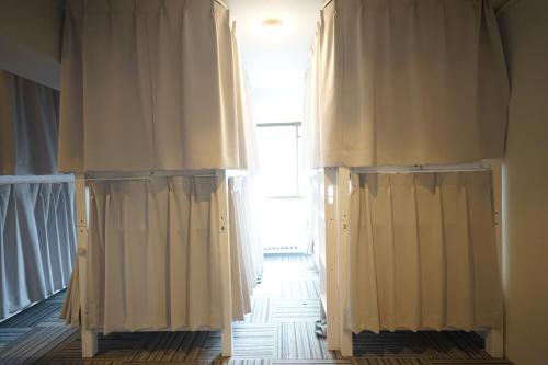 a room with white curtains and a window at ゲストハウス ブランク Guest House BLANC in Hiroshima