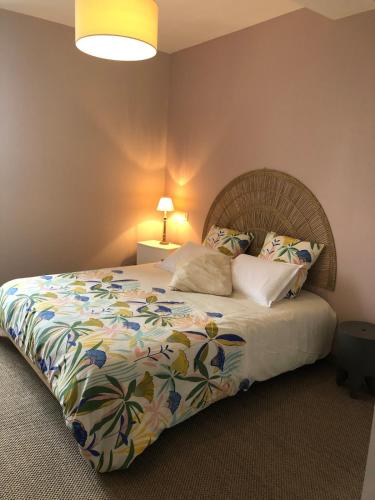 a bedroom with a bed with a colorful comforter at Maison village entre pau et lourdes in Boeil-Bezing