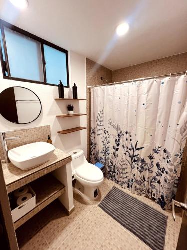 a bathroom with a toilet and a shower curtain at Private Patio, Peaceful and Centric in Cedro