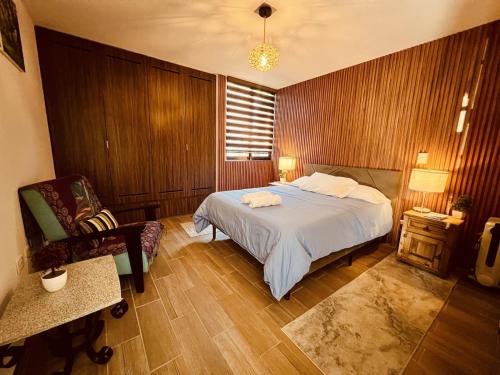 a bedroom with a bed and a chair in it at Private Patio, Peaceful and Centric in Cedro
