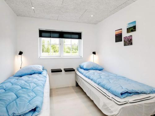 two beds in a room with white walls at 8 person holiday home in Læsø in Læsø