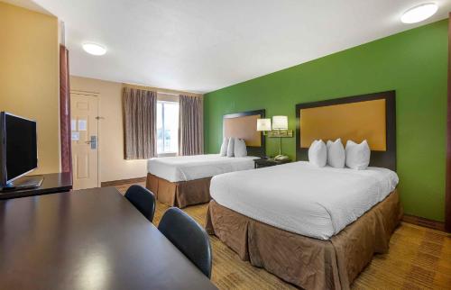a hotel room with two beds and a flat screen tv at Extended Stay America Suites - Albuquerque - Airport in Albuquerque
